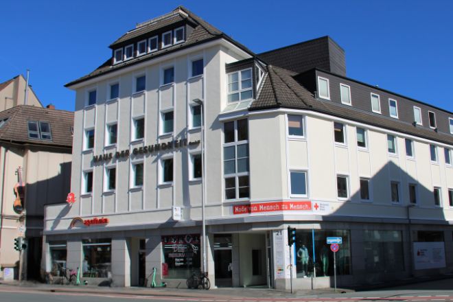 Ein weiß gestrichenes Geschäftshaus an einer Straßenkreuzung.