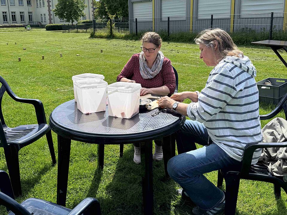Coerde Garden Schnibbeln Zwei Frauen sitzen an einem Tisch und schneiden Gemüse