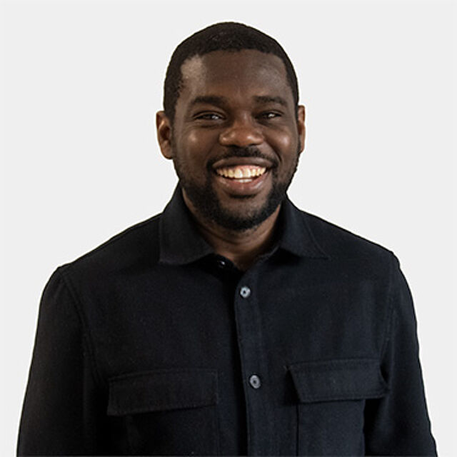 Ein Mann mit schwarzen Haaren, der ein Hemd trägt.