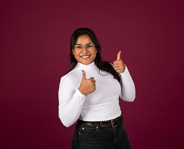 Junge Frau mit dunklen Haaren vor dunkelrotem Hintergrund