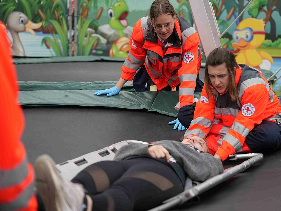 Fallbeispieltraining Send Zwei Einsatzkräfte versorgen eine betroffene Person auf einem Trampolin
