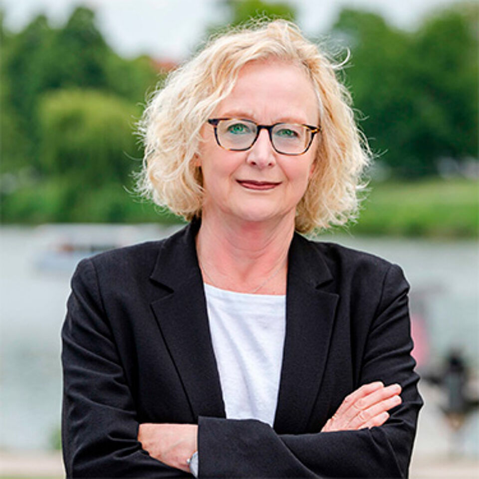 Eine Frau mit blonden Haaren und Brille.