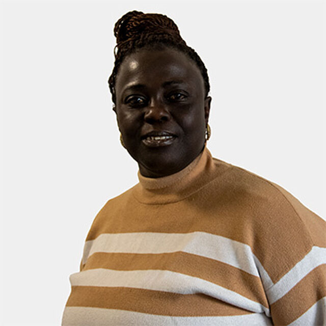 Eine Frau mit schwarzen Haaren und braunem Pullover