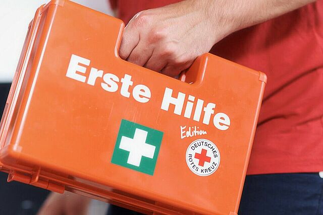 Ein Mann bringt einen Erste Hilfe Koffer