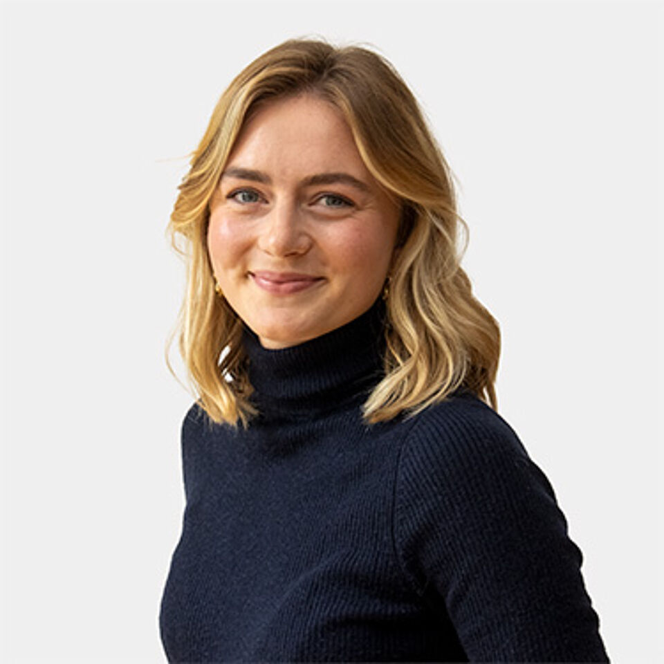 Eine Frau mit langen blonden Haaren in einem schwarzen Pullover
