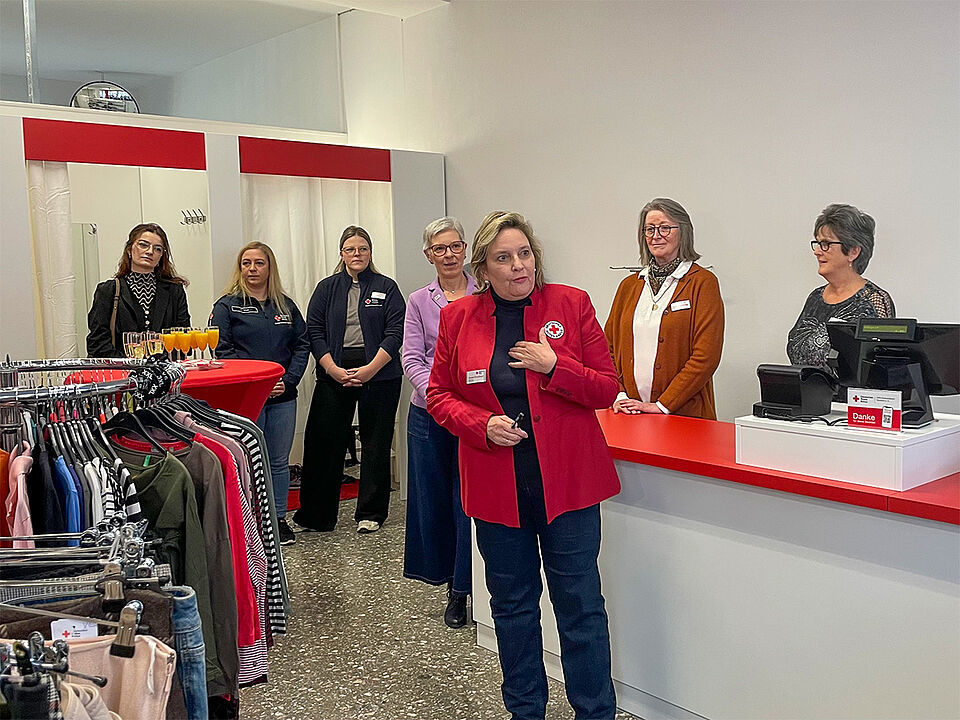 Eröffnung Kleiderladen Vizepräsidentin Eine Frau in einem roten Blazer hält eine Rede