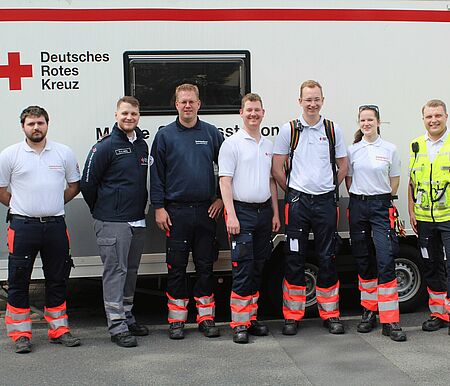 Gruppenbild mit sieben Einsatzkräften vor der Unfallshilfsstation