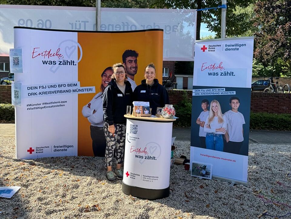Zwei Frauen stehen an einem Stand mit Informationen zum DRK-Freiwilligendienst