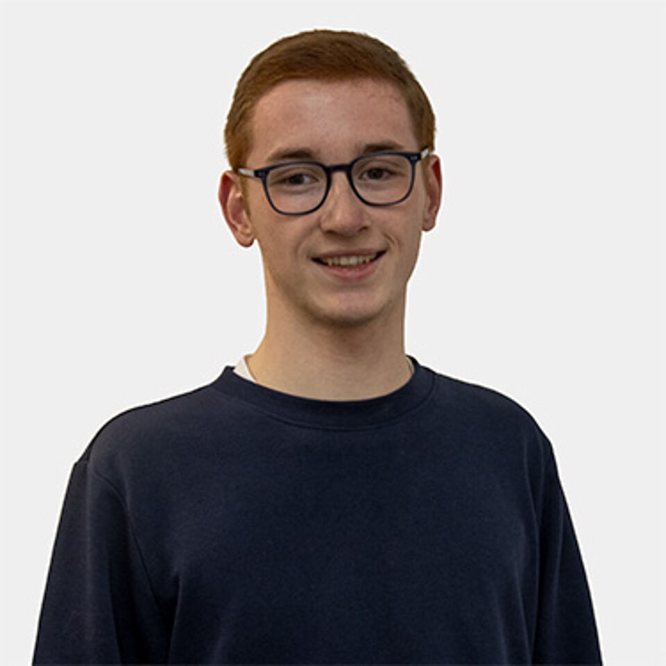 Ein junger Mann mit kurzen Haaren und Brille