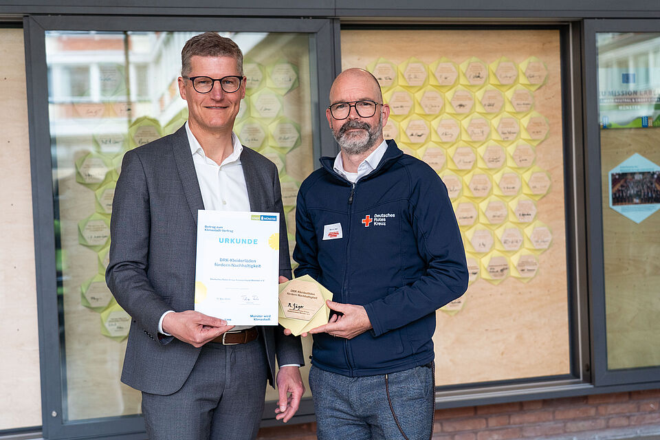 Zwei Männer mit einer Urkunde und einer Plakette