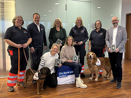 Ein Gruppenbild mit acht Personen und zwei Hunden