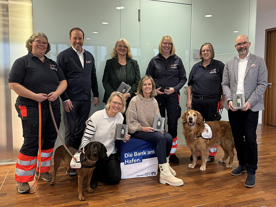 Ein Gruppenbild mit acht Personen und zwei Hunden