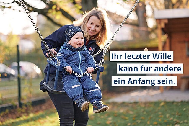 Eine Frau gibt einem Kleinkind auf einer Schaukel Schwung.