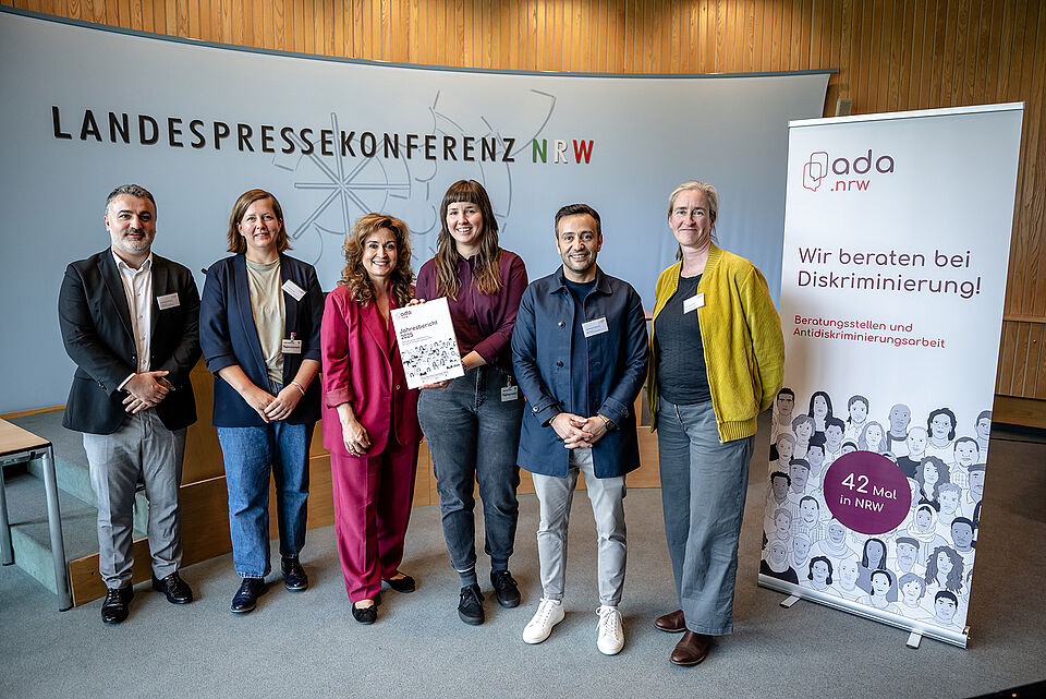 Landespressekonferenz ada.nrw Gruppe 6 Personen stehen vor einem Podium