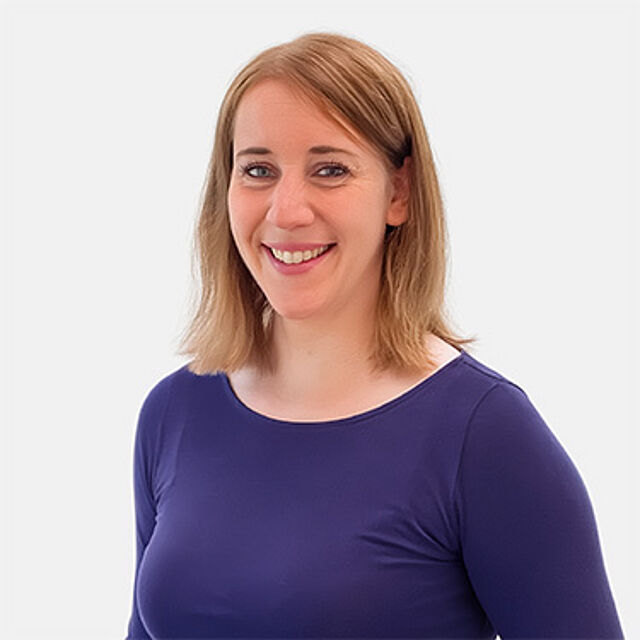 Eine Frau mit mittellangen Haaren in einem blauen Shirt
